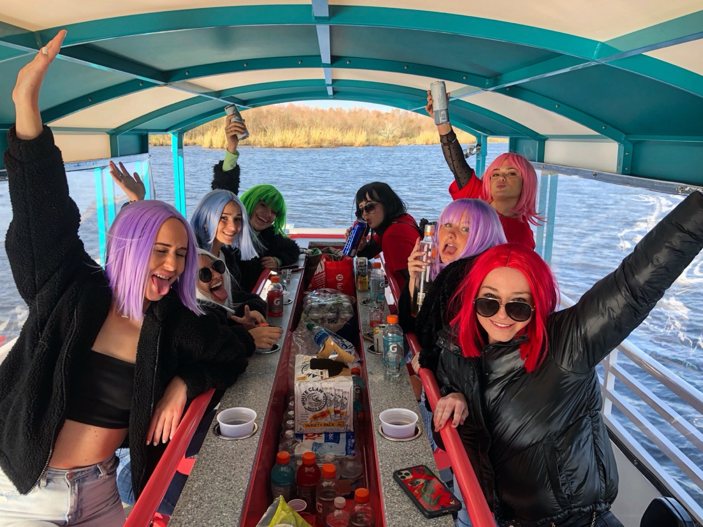 Bachelorette party wearing colorful wigs celebrating aboard the Party Queen