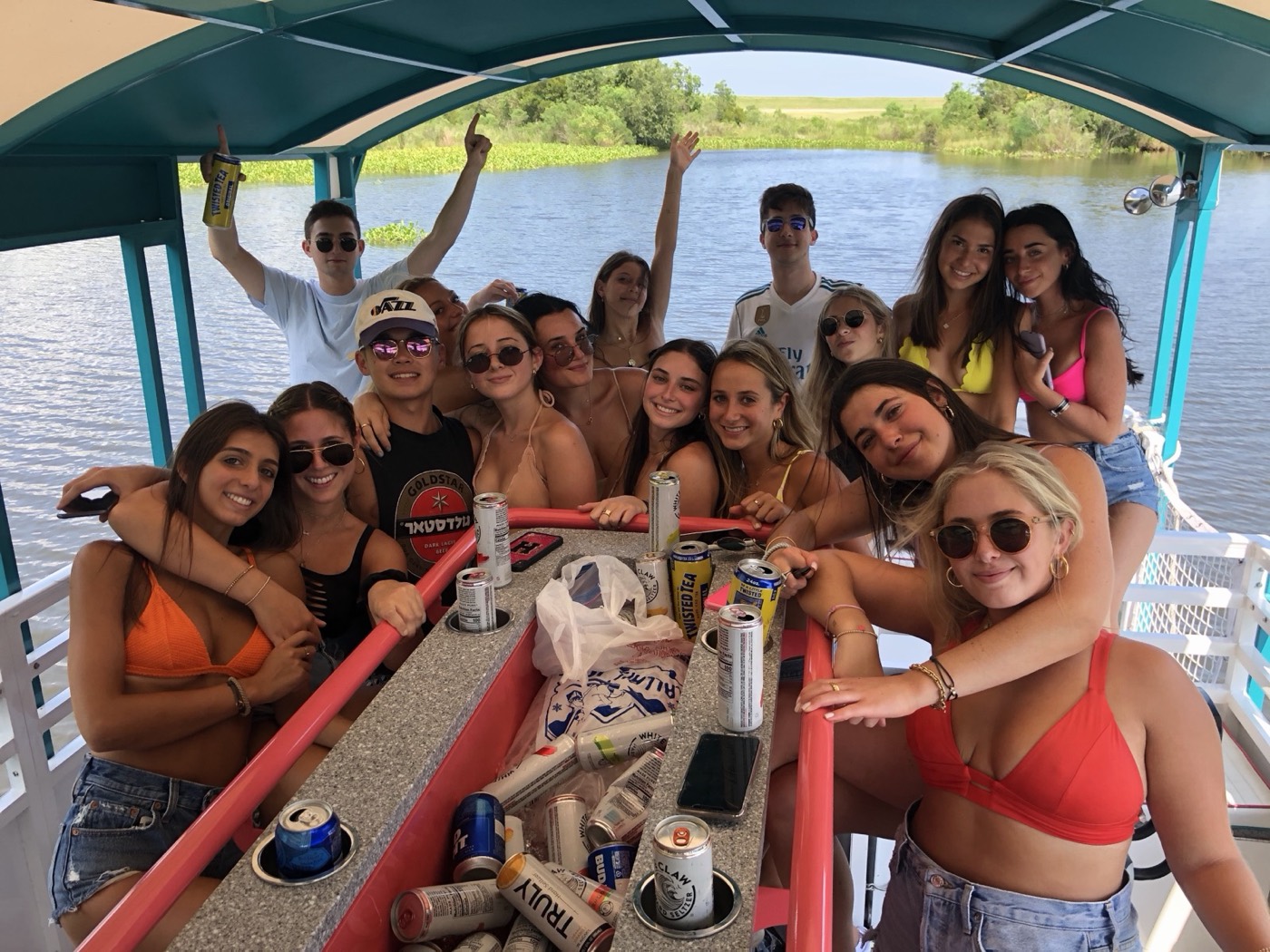 Group of friends celebrating on the Bayou Boogie party barge under a teal canopy