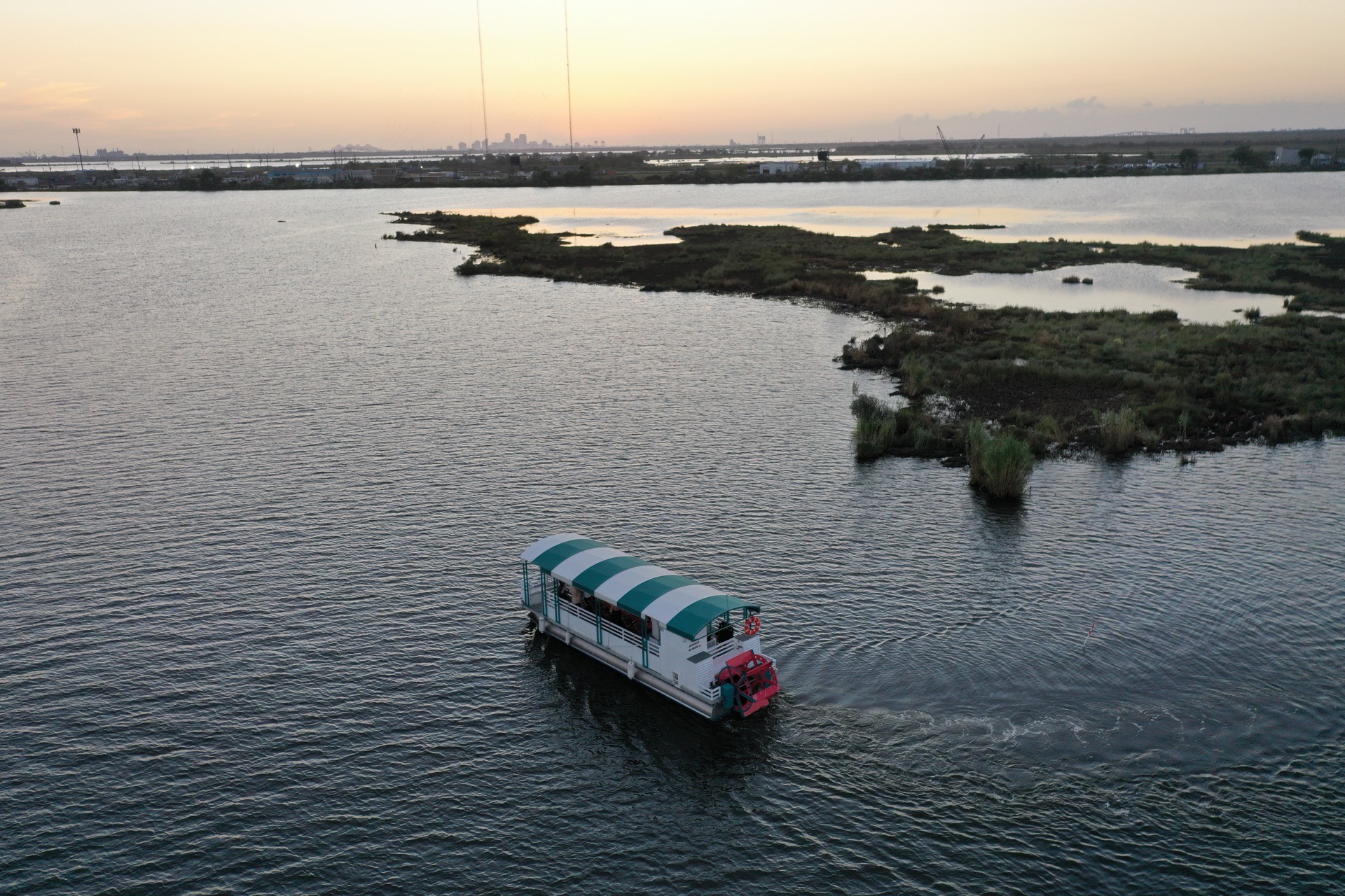 Aerial view of a party barge cruising the bayou at sunset near New Orleans