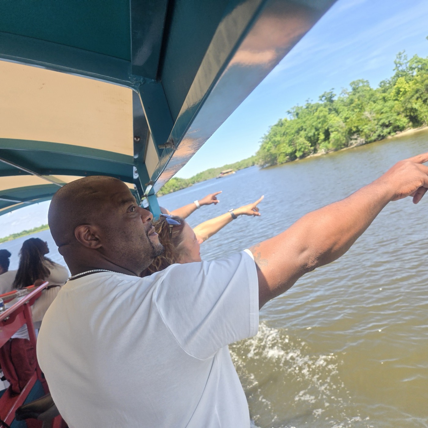 Captain pointing out the shoreline on a Bayou Bienvenue swamp tour