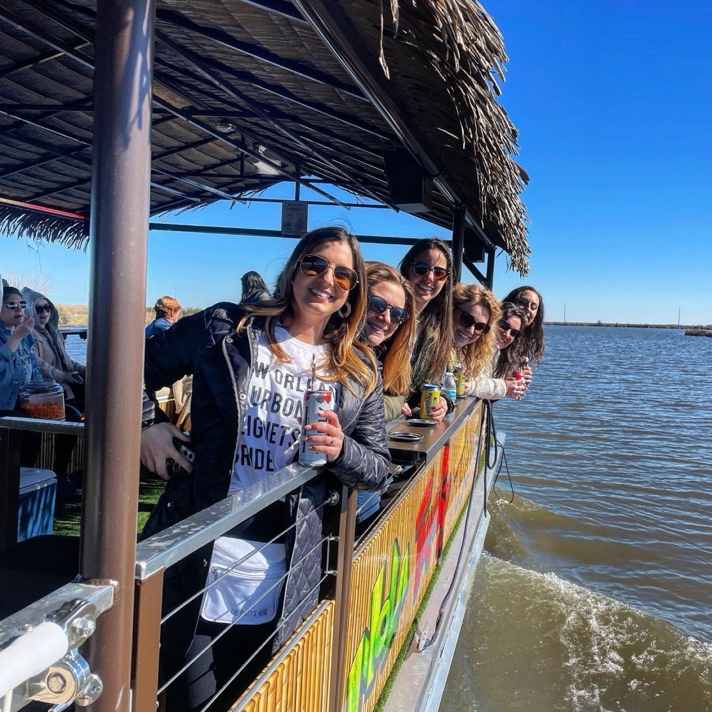 Guests laughing along the rail of the Twerkin' Tiki party boat in New Orleans